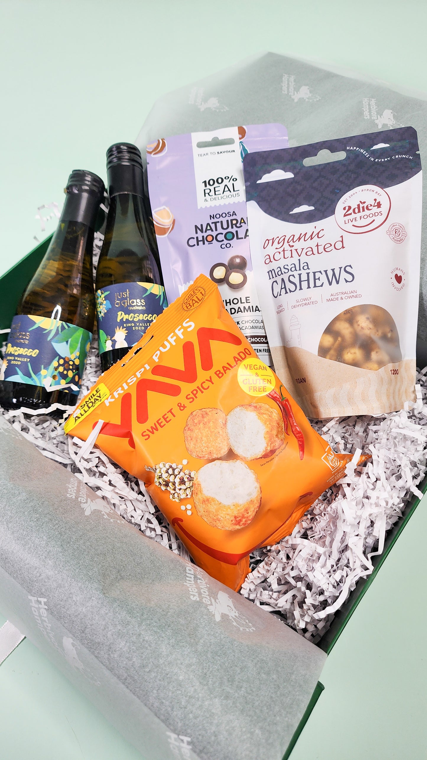 wine and gourmet items in front of green hamper box